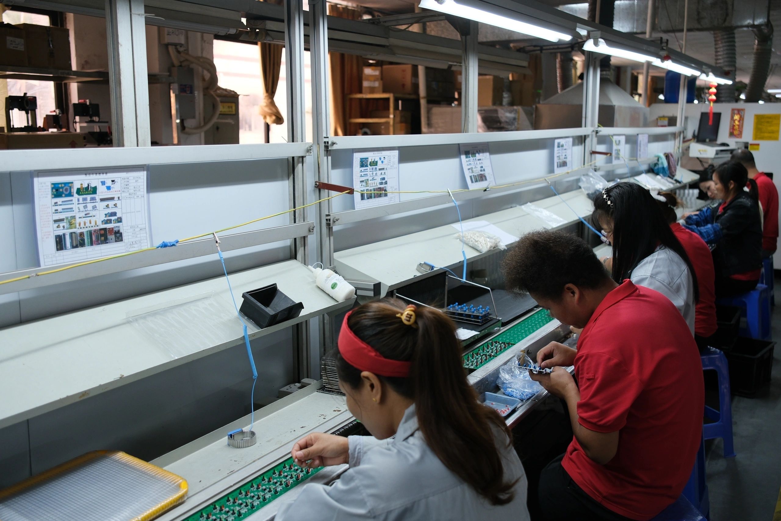 Team inserting components into circuit boards on an assembly line